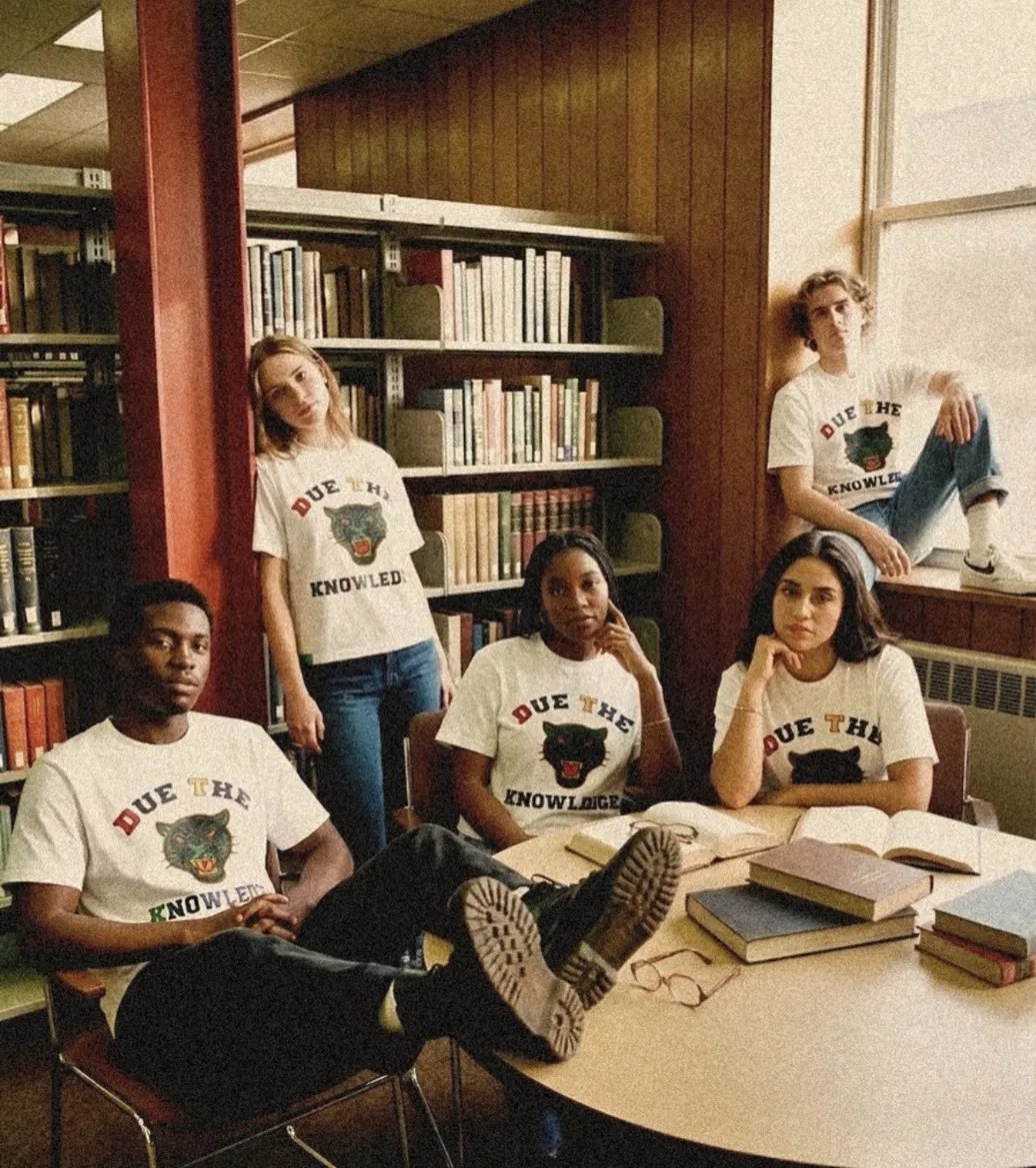 A vintage-style crowd photo with a raised DTK sign bearing the panther crest.